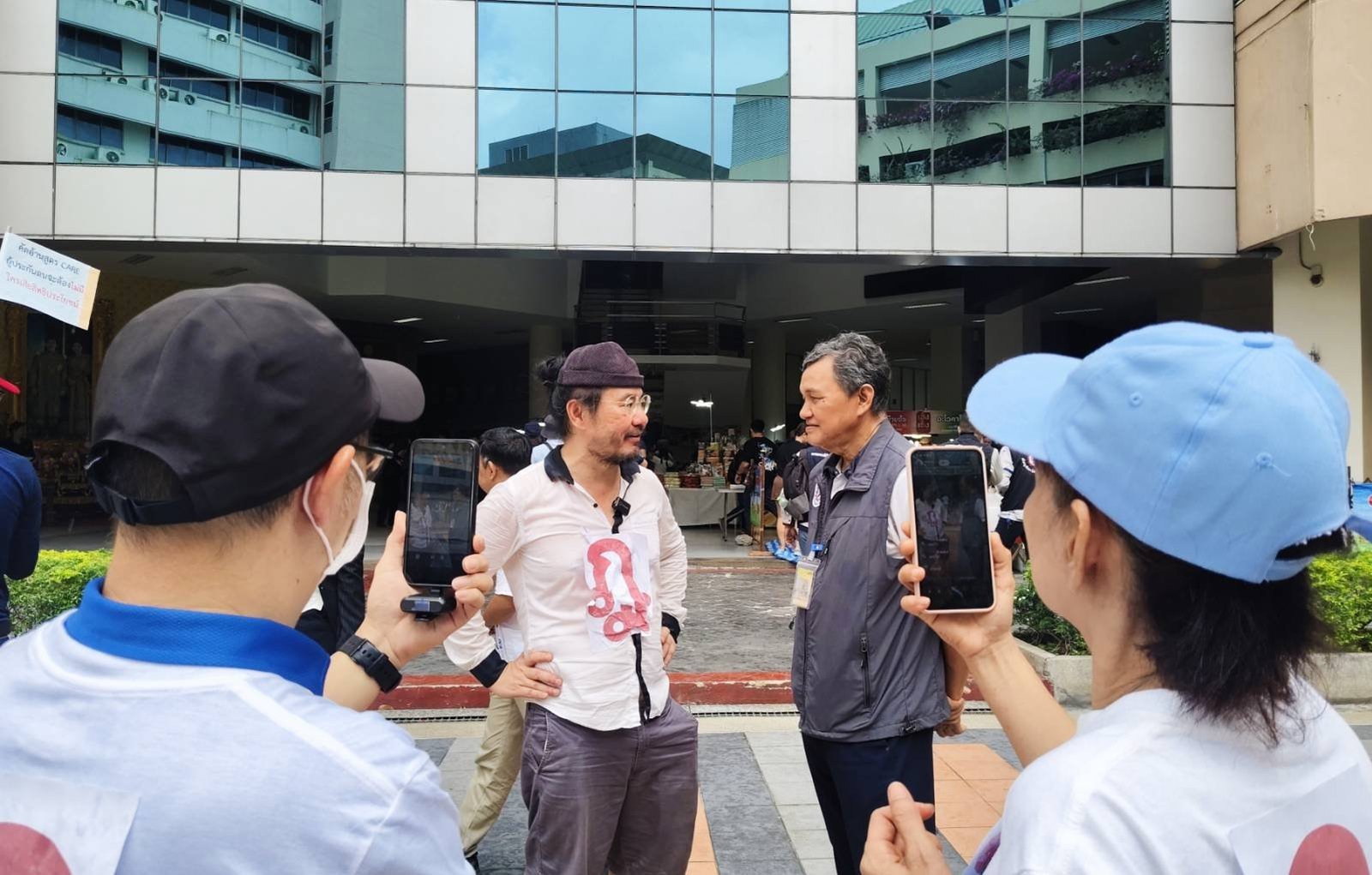 Supporters record the key discussion between Dr. Boon and Sawit Kaewwan at Ministry of Labour — broadcast live to thousands