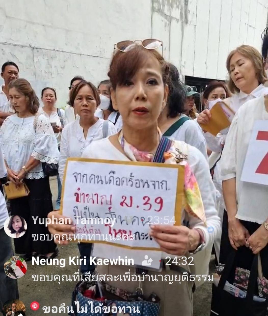 Protester holds sign reading millions of Section 39 workers are suffering — Hohn Krasae