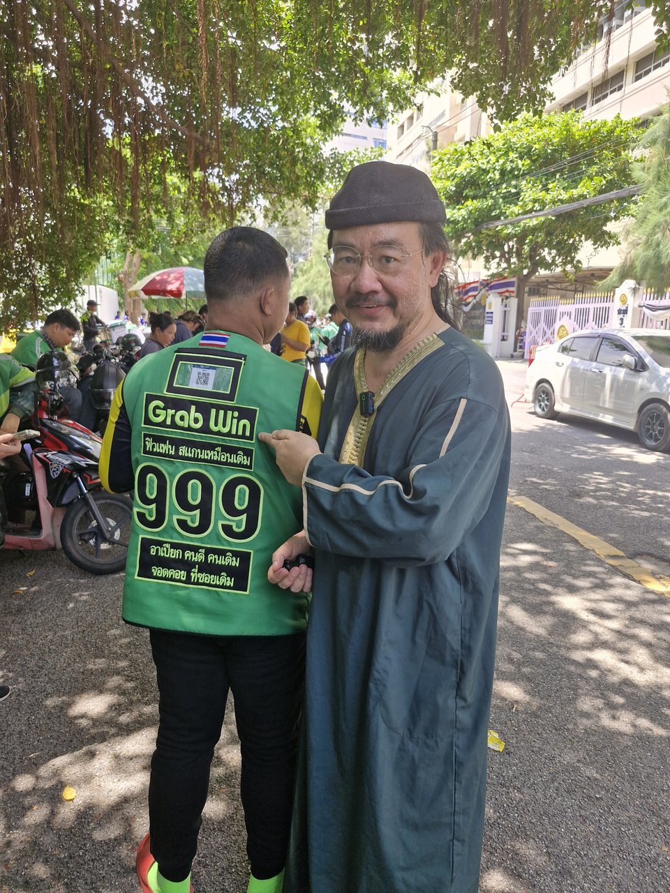 หมอบูรณ์ อารยพล จับไหล่พูดคุยกับไรเดอร์ Grab Win หน้ากระทรวงแรงงาน